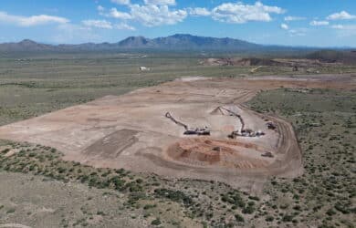 Aerial view of the Johnson Camp mine's construction progress. Heavy equipment moves earth.